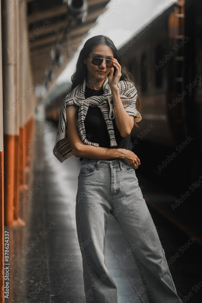 Stylish young woman striking a pose on a train platform while awaiting her journey to begin Stylish young woman striking a pose on a train platform while awaiting her journey to begin