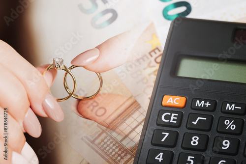 Wedding rings on money. Cost of wedding. Price of getting married background. Golden jewelry on banknote. Cash for getting divorced. Expensive marriage. Fifty euro note. Engagement money.
