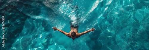 Top view of swimmer swimming in a crystal clear blue water pool 