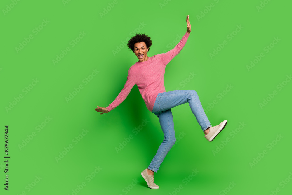 Full length photo of attractive funny guy wear pink sweater having fun emtpy space isolated green color background Full length photo of attractive funny guy wear pink sweater having fun emtpy space isolated green color background