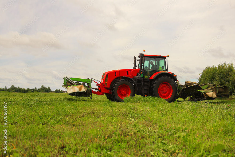 tractor, feed, harvesting, hay. A tractor mows the grass. haymaking, fodder harvesting. Copy space tractor, feed, harvesting, hay. A tractor mows the grass. haymaking, fodder harvesting. Copy space