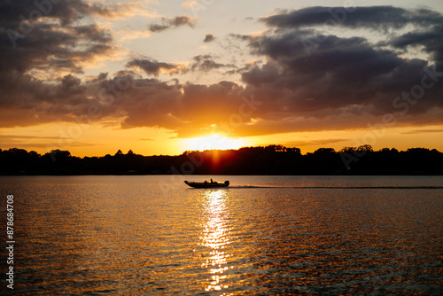 Beautiful sky and lake with boats, people relaxing on the shore at sunset. Beautiful orange and blue sky at dawn. Lake Bowen Anchor Park, Inman, SC, USA  photo