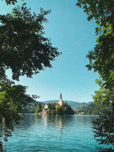 ﻿Nesta imagem encantadora, o Lago de Bled ocupa o centro, exibindo suas águas serenas e cristalinas. No meio do lago, a icônica igreja na ilha parece flutuar, rodeada numa paisagem de tirar o fôlego. photo