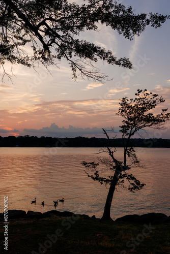 Beautiful sky and lake with boats, people relaxing on the shore at sunset. Beautiful orange and blue sky at dawn. Lake Bowen Anchor Park, Inman, SC, USA  photo