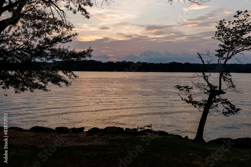 Beautiful sky and lake with boats, people relaxing on the shore at sunset. Beautiful orange and blue sky at dawn. Lake Bowen Anchor Park, Inman, SC, USA  photo