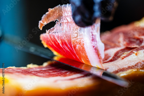 Chef cutting dry-cured spanish ham Jamon.