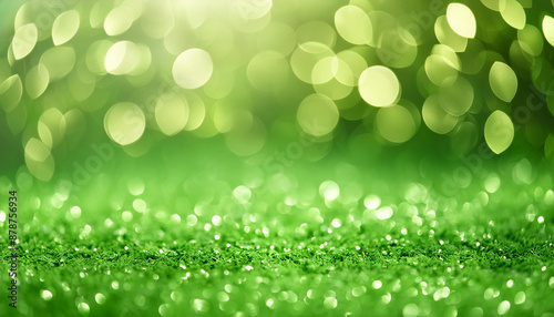 Glittery vibrant green background with dreamy bokeh effect. Abstract festive backdrop.