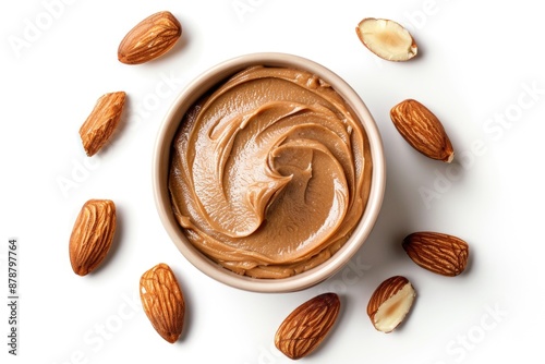 A bowl filled with creamy nut butter and surrounded by whole almonds for snacking or cooking