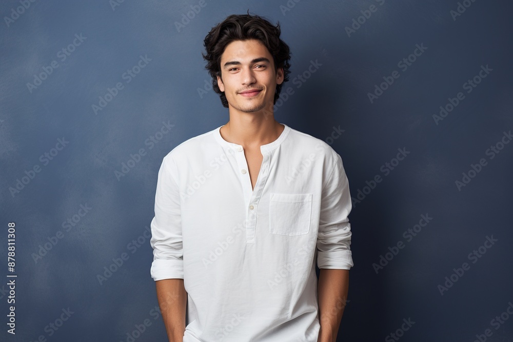 A man in a white shirt is smiling and posing for a picture A man in a white shirt is smiling and posing for a picture