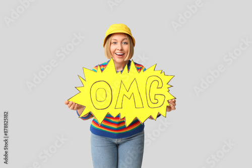 Surprised adult woman holdi...