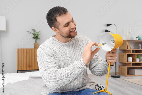 Young man changing light bu...