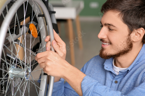 Young man repairing wheelch...