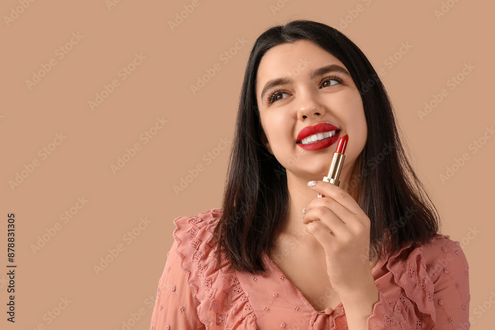 Happy young woman with red lips and lipstick on brown background
