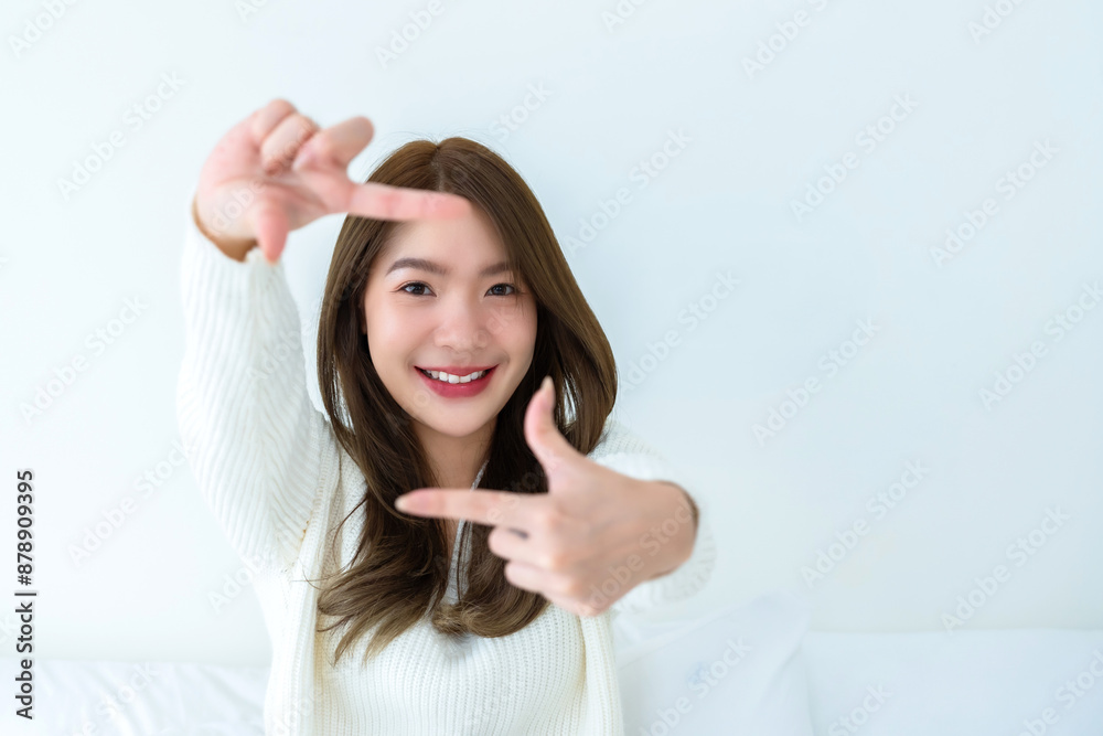 Young asian woman happy and making frame with fingers on white background in house Young asian woman happy and making frame with fingers on white background in house
