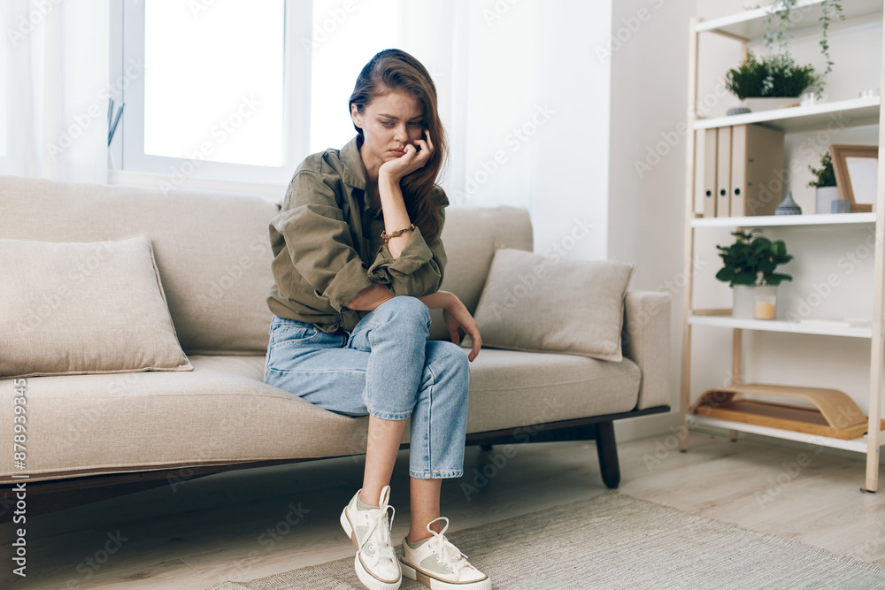 Stressed Woman Contemplating Despair on a Sad Couch, Worried and Upset with Mental Health Troubles at Home Stressed Woman Contemplating Despair on a Sad Couch, Worried and Upset with Mental Health Troubles at Home