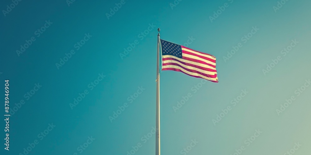 American Flag Waving in the Wind Against a Blue Sky American Flag Waving in the Wind Against a Blue Sky