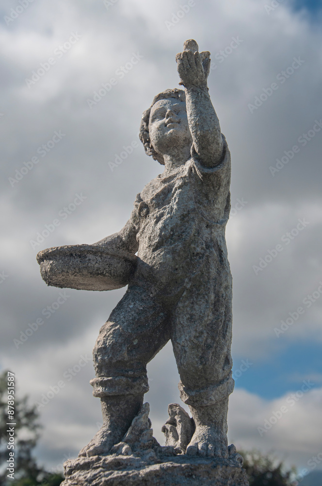 Fototapeta premium a statue of a boy holding the sky