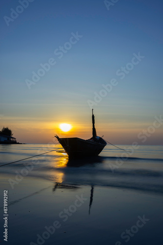A lone fishing boat on a beautiful calm sea during sunset