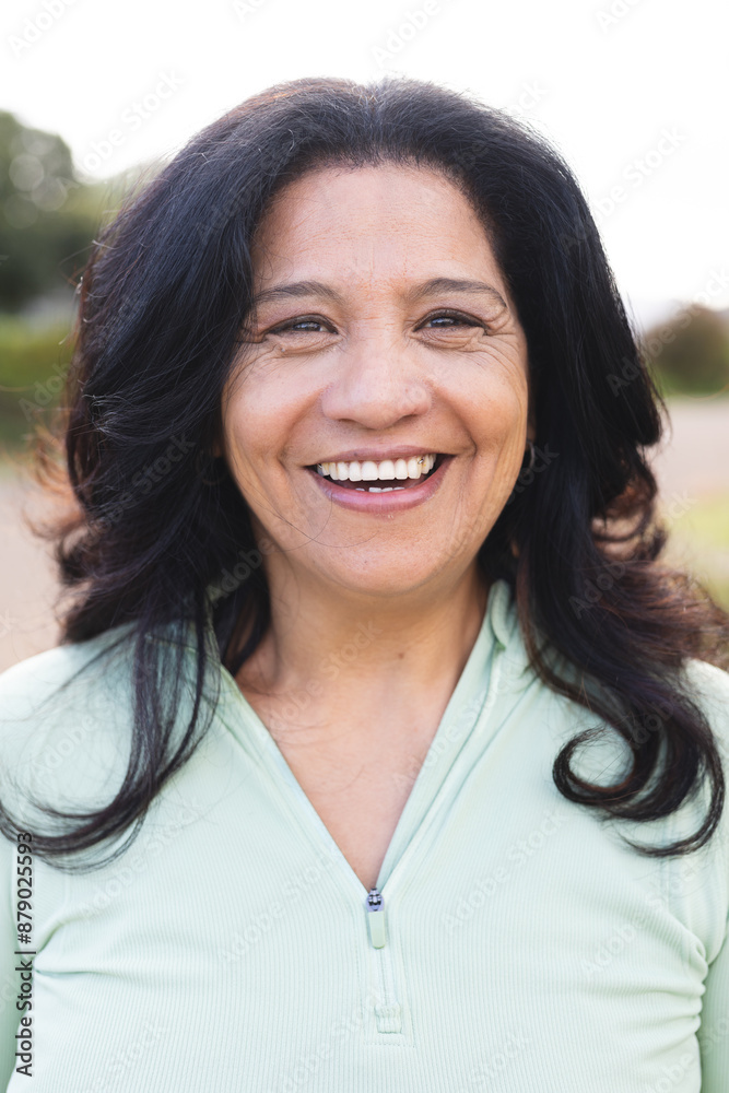 Portrait of happy senior biracial woman with long black hair smiling outdoors Portrait of happy senior biracial woman with long black hair smiling outdoors