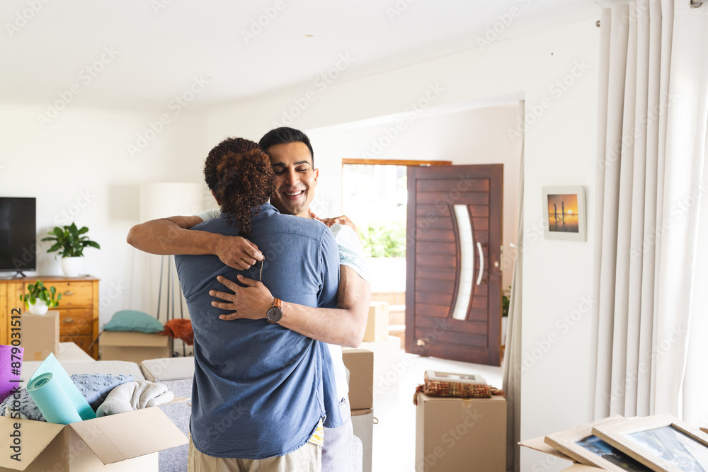 Young biracial man embracing a middle eastern man at home, with copy space Young biracial man embracing a middle eastern man at home, with copy space