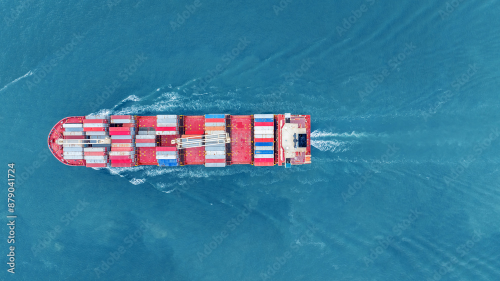Fototapeta premium Cargo container ship carrying container and running in the ocean near international container port customs shipyard sea port concept smart logistic service. transportation logistics trading..