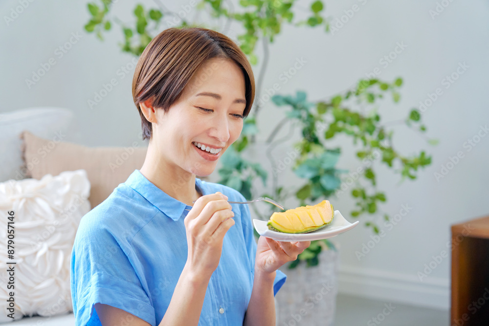 自宅でメロンを食べる女性