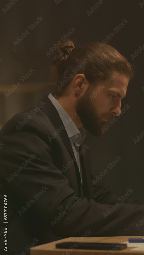 Face of serious bearded attractive businessman sit at desk working. Use laptop at night office. Concentrate on work Face of serious bearded attractive businessman sit at desk working. Use laptop at night office. Concentrate on work
