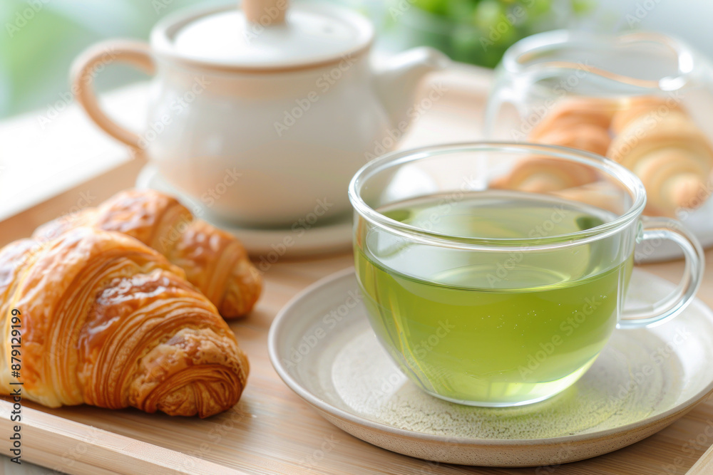 A cup of green tea and croissant on table at hotel restaurant cafe A cup of green tea and croissant on table at hotel restaurant cafe