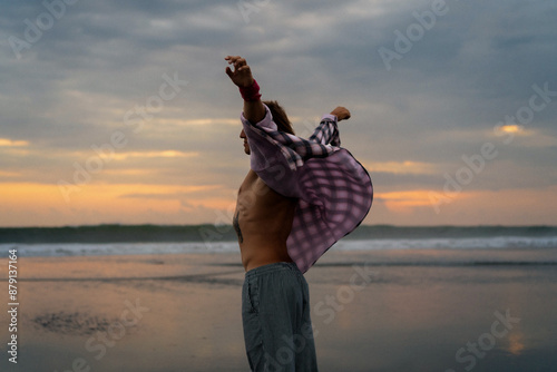 Happy man at sunset on the ocean beach. photo