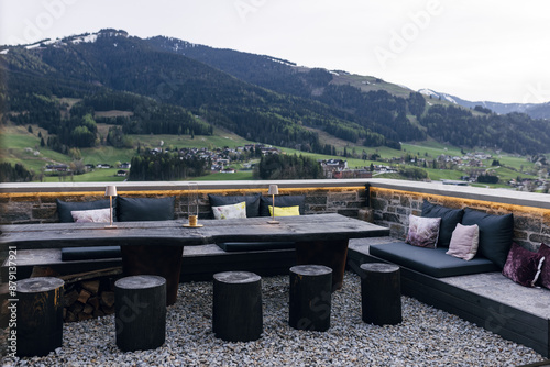 Outdoor patio with wooden furniture and mountain view photo