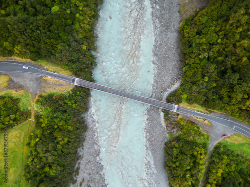 Obraz na płótnie Fox Glacier, New Zealand: Overhead drone view of a car crossing the bridge over the Karangarua river near Fox glacier town in New Zealand south island wild west coast. w salonie