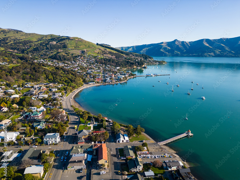 Akaroa, New Zealand: Aerial drone view of the stunning Akaroa idyllic village in the Banks Peninsula in the Christchurch region of Canter bury in New Zealand south island on a sunny day.