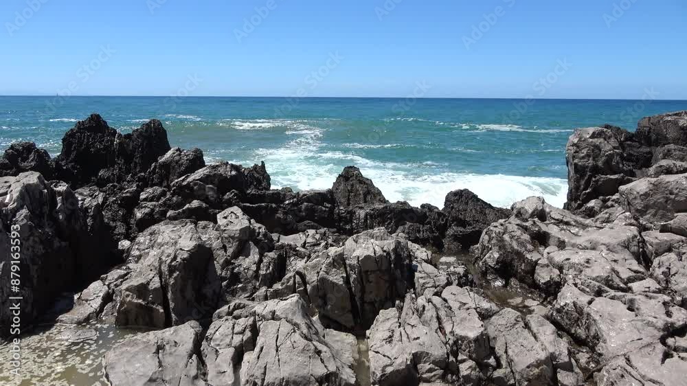 Ocean waves crashing on rocks on sunny day Ocean waves crashing on rocks on sunny day