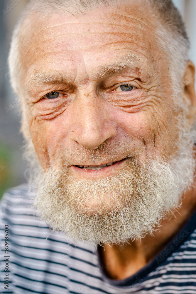 Portrait of mature man looking on camera outside at the park. Concept of alone senior aged male people elderly lifestyle. Loneliness and care. Retired lifestyle. Defocused background Portrait of mature man looking on camera outside at the park. Concept of alone senior aged male people elderly lifestyle. Loneliness and care. Retired lifestyle. Defocused background