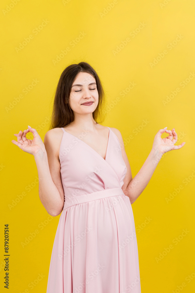 Smiling pregnant woman standing and practicing yoga isolated on colored background Smiling pregnant woman standing and practicing yoga isolated on colored background