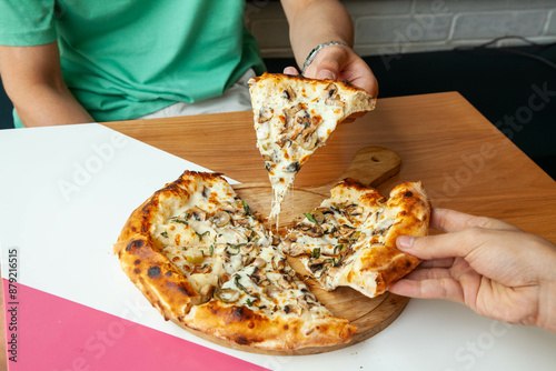 Italian authentic naples pizza four cheese and all vegetable and mushrooms, eating at a restaurant.