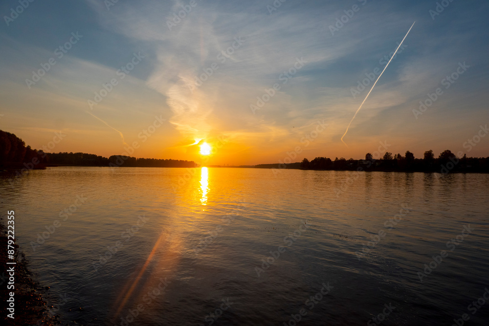 Sunset by river with tree silhouette. High quality photo