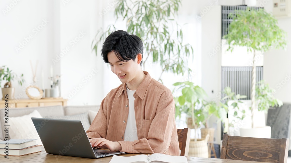 自宅でノートパソコンを使う男性	