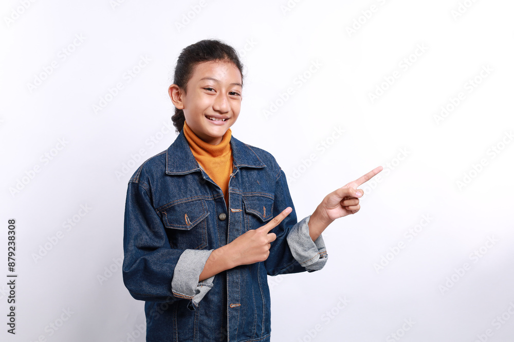 Amazed asian young female kid pointing at copy space isolated over white background Amazed asian young female kid pointing at copy space isolated over white background