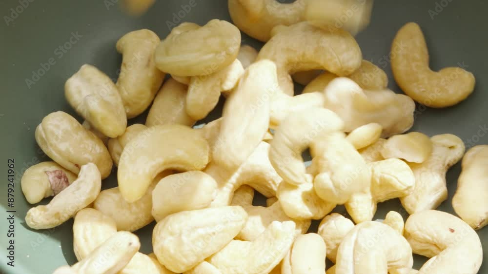 Overview of Dried Cashew Nuts Tumbling in Slow Motion into Bowl Outside in Sunlight - 4K Food Clip Overview of Dried Cashew Nuts Tumbling in Slow Motion into Bowl Outside in Sunlight - 4K Food Clip