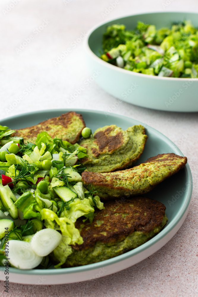 Zucchini and broccoli pancakes served with a mixed salad of cucumbers, young peas, and radishes. This healthy vegetarian dish is both delicious and nutritious Zucchini and broccoli pancakes served with a mixed salad of cucumbers, young peas, and radishes. This healthy vegetarian dish is both delicious and nutritious