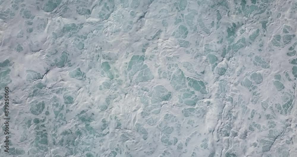 Rapid, powerful waves crash against the coast of Maui, Hawaii, and create a frothy white foam and bubbles. Top-down perspective with a static drone view Rapid, powerful waves crash against the coast of Maui, Hawaii, and create a frothy white foam and bubbles. Top-down perspective with a static drone view