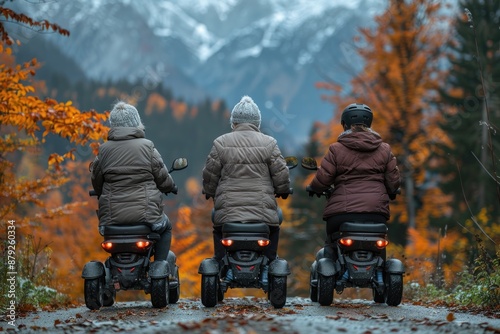 Three elderly women riding electric scooters through a scenic autumn photo