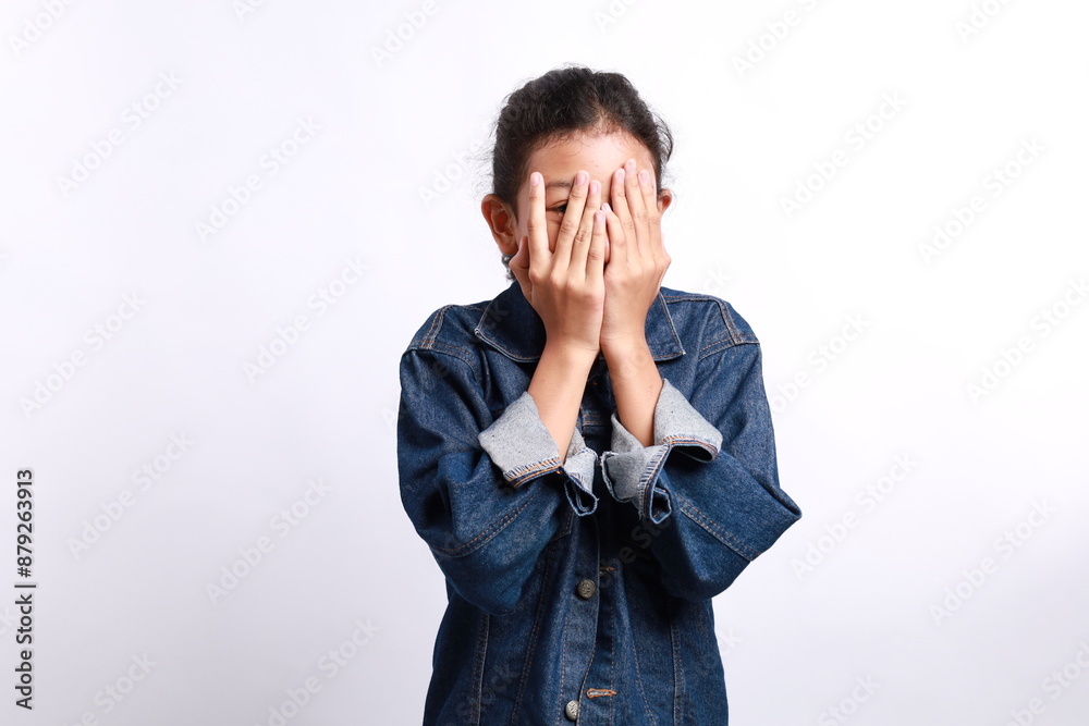 Cute little Asian girl peeks through his fingers, isolated on white background Cute little Asian girl peeks through his fingers, isolated on white background