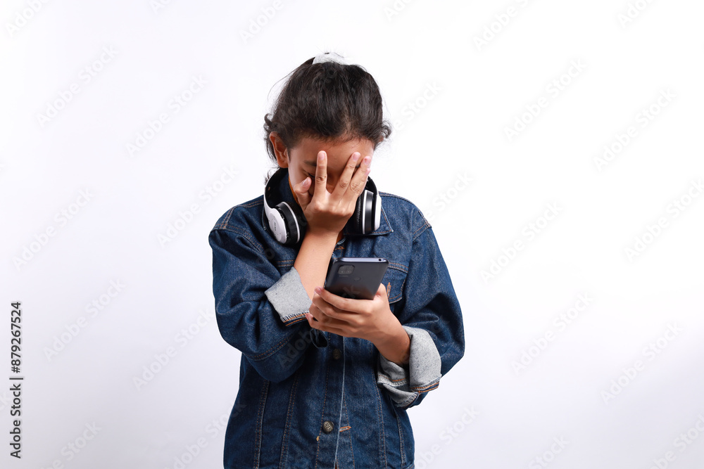 Shocked asian boy while looking at his cellular phone. Isolated on white background Shocked asian boy while looking at his cellular phone. Isolated on white background