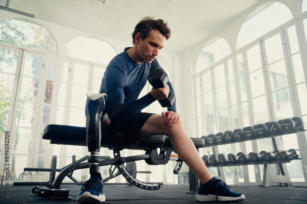Young caucasian man with prosthetic leg doing weightlifting exercises with dumbbell at the gym Young caucasian man with prosthetic leg doing weightlifting exercises with dumbbell at the gym