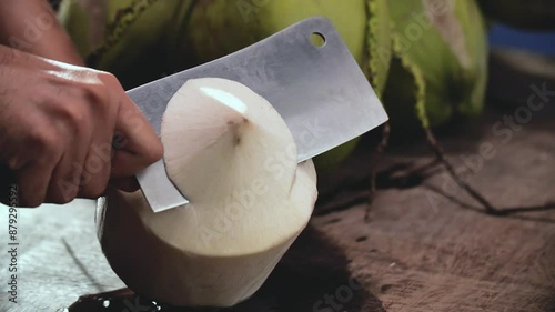 Hand with Knife Chop Whole Coconut, Close Up