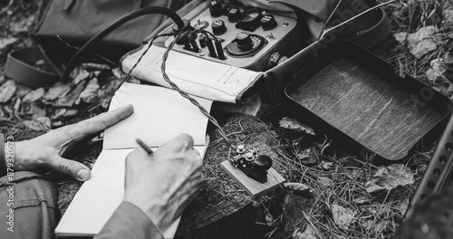 Russian Soviet Infantry Red Army Soldier In World War II using Russian Soviet Portable Radio Transceiver In Trench Entrenchment In Spring Autumn Forest. . Headphones And Telegraph Key. Close Up Hands
