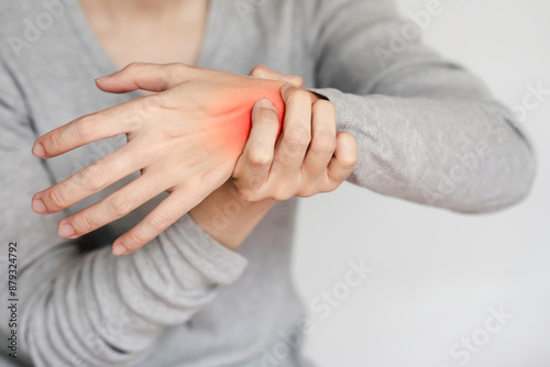 Close-up of a person's hand experiencing wrist pain and discomfort, highlighted by a red mark, showcasing a health issue or injury.