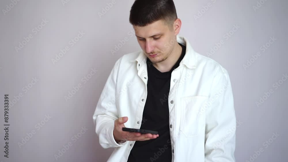A man in a white shirt stands against the wall and rings his phone.
A man works on the phone.
A man uses the Internet. A man in a white shirt stands against the wall and rings his phone.
A man works on the phone.
A man uses the Internet.